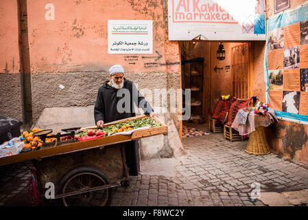 Homme marocain vente de fruits et légumes à partir d'un panier à Marrakech Banque D'Images