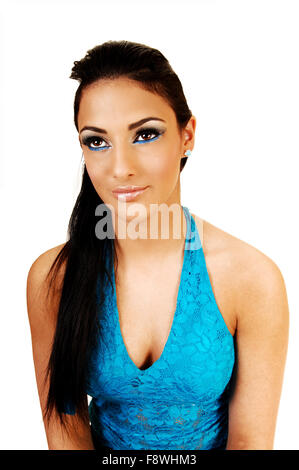 Un portrait d'une tige étroite jolie fille adolescente avec ses longs cheveux noirs et un corset bleu, à la suite, fond blanc. Banque D'Images