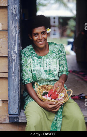 Îles Fidji, de Nukubati Island Resort, membre du personnel de l'île des femmes assis dans la porte avec des fleurs de plumeria choisi Banque D'Images