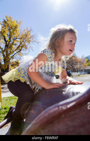 Quatre ans, petite fille jouant à l'extérieur sur un jeu extérieur dans un parc Banque D'Images
