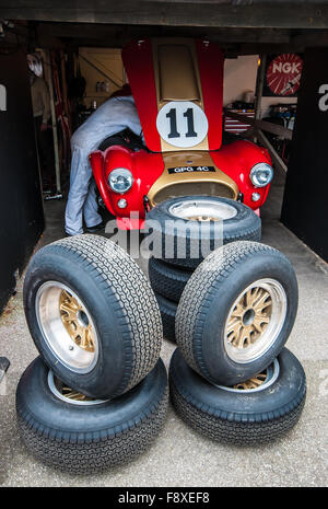 1964 course Cobra GPG 4C appartenant à Grahame Bryant et son fils Olly. Photographié ici au Goodwood Revival 2015 dans un garage avec roues de secours Banque D'Images