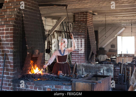 Williamsburg, Virginie - une histoire vivante en costume d'artisan travaille à la forge à Colonial Williamsburg. Banque D'Images