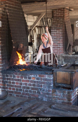Williamsburg, Virginie - une histoire vivante en costume d'artisan travaille à la forge à Colonial Williamsburg. Banque D'Images