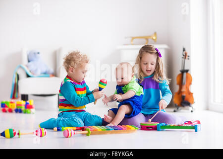 Les enfants avec des instruments de musique. L'éducation musicale pour les enfants. Art toys en bois coloré. Petite fille et garçon de jouer de la musique. Banque D'Images