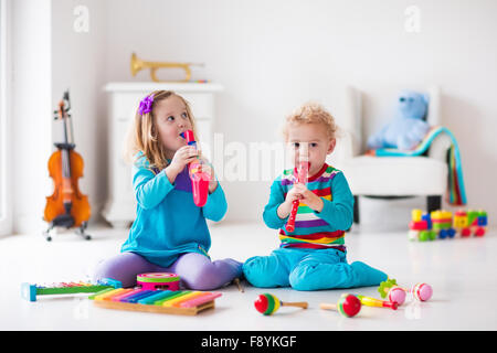 Les enfants avec des instruments de musique. L'éducation musicale pour les enfants. Art toys en bois coloré. Petite fille et garçon de jouer de la musique. Banque D'Images