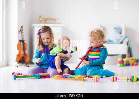 Les enfants avec des instruments de musique. L'éducation musicale pour les enfants. Art toys en bois coloré. Petite fille et garçon de jouer de la musique. Banque D'Images