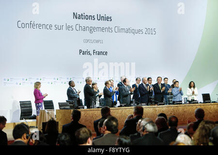 Le Bourget, Paris, France. 12 Décembre, 2015. Pariticants sur la tribune applaudissements au cours de la COP21 sur le climat organisée au Bourget, au nord de Paris, le 12 décembre 2015. France Le samedi a prononcé le texte final d'un accord mondial sur le changement climatique aux participants du marathon des négociations climatiques à Paris. (Xinhua/Zhou Lei)(l'azp) Credit : Xinhua/Alamy Live News Banque D'Images