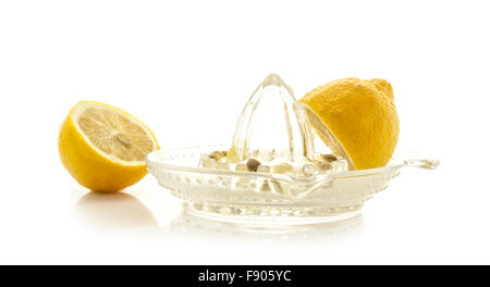 Presse-agrumes en verre de jus de citrons et sur un fond blanc Banque D'Images