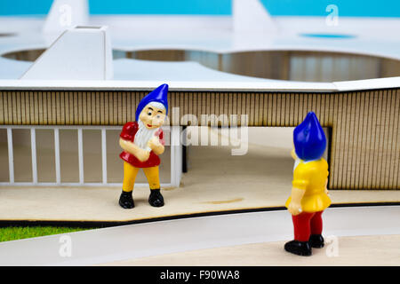 Deux nains de jardin en face d'un bâtiment miniature Banque D'Images