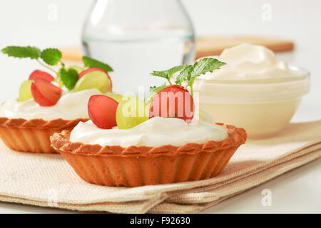 Petites tartelettes à la crème garnie de raisins frais Banque D'Images