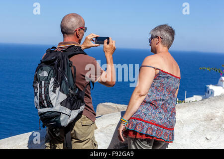 Vieillissement actif Senior couple personnes touristes prendre photo adulte Seniors retraités retraités vieillards homme femme Îles grecques Oia Santorini Grèce Europe Banque D'Images