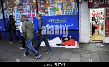 Brighton, UK. 13 Décembre, 2015. Tout le monde ne peut pas profiter de la Christmas shopping à Brighton comme cet homme dort sur le trottoir devant un 99p Store sur l'un des plus occupés shopping week-end de l'année en Grande-Bretagne Crédit : Simon Dack/Alamy Live News Banque D'Images