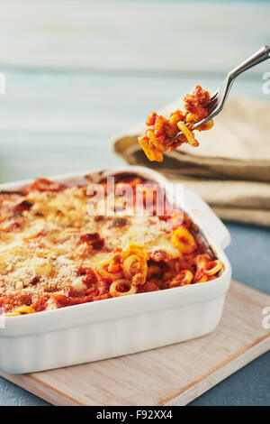 Anelletti au four avec petits pâtes, la sauce et de la mozzarella. Sicilienne typique plat de pâtes avec sauce tomate, viande hachée et fromage, cuit au four Banque D'Images