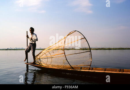 Jambe avec rameur traditionnel filet de pêche conique iconique au début de lumière du matin sur le lac Inle, l'État de Shan, Myanmar Banque D'Images