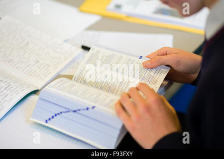 L'enseignement secondaire au Pays de Galles UK : un garçon à la définition d'un mot dans un dictionnaire au cours d'une leçon d'anglais de GCSE dans une salle de classe Banque D'Images