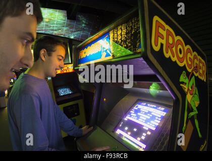 Garden City, New York, USA. Dec 12, 2015. SETH ROSEN, 15, à droite, à partir de Roslyn, NY, et son cousin JACOB ROSEN, 21, de Miami, Floride, jouer FROGGER, un jeu Sega 1981 Gremlin, lors de la journée d'ouverture de l'Arcade de l'âge de la pièce, où les visiteurs font l'expérience de jouer jeux d'arcade classique authentique en mis en place au berceau de l'Aviation Museum à Long Island. L'entrée inclut un nombre illimité de pay-to-play de jeux vidéo pour borne d'arcade, jeux et l'histoire est affiché à l'extérieur de la zone d'arcade. La pièce se déroule du 12 décembre 2015 au 3 avril 2016. © Ann Parry/ZUMA/Alamy Fil Live News Banque D'Images