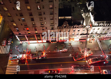 New York, USA. 13 Décembre, 2015. Les camions de l'échelle et de crochet sont sur les lieux avec les pompiers sur le toit d'un immeuble brownstone. Credit : Patti McConville/Alamy Live News Banque D'Images