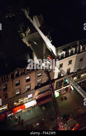 New York, USA. 13 Décembre, 2015. Les camions de l'échelle et de crochet sont sur les lieux avec les pompiers sur le toit d'un immeuble brownstone. Credit : Patti McConville/Alamy Live News Banque D'Images