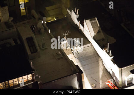 New York, USA. 13 Décembre, 2015. Les camions de l'échelle et de crochet sont sur les lieux avec les pompiers sur le toit d'un immeuble brownstone. Credit : Patti McConville/Alamy Live News Banque D'Images