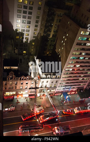 New York, USA. 13 Décembre, 2015. Les camions de l'échelle et de crochet sont sur les lieux avec les pompiers sur le toit d'un immeuble brownstone. Credit : Patti McConville/Alamy Live News Banque D'Images