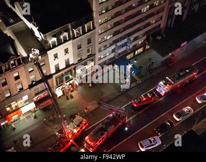 New York, USA. 13 Décembre, 2015. Les camions de l'échelle et de crochet sont sur les lieux avec les pompiers sur le toit d'un immeuble brownstone. Credit : Patti McConville/Alamy Live News Banque D'Images