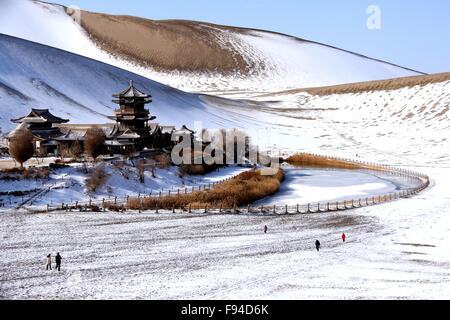 Jiuquan, province du Gansu en Chine. 13 Décembre, 2015. Personnes visitent le paysage du lac Crescent en place de montagne Mingsha Dunhuang, ville du nord-ouest de la Chine la province de Gansu, le 13 décembre 2015. © Zhang Xiaoliang/Xinhua/Alamy Live News Banque D'Images