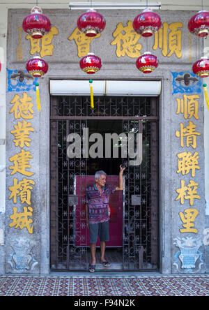 L'homme chinois dans l'entrée d'une vieille maison coloniale, l'île de Penang, George Town, Malaisie Banque D'Images