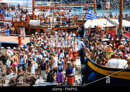 Santorin. Erinia Bay, Nea Kameni. Excursion bateaux amarrés à paniers jetée avec des foules de touristes de l'embarquement et du débarquement sur visiter le volcan. Banque D'Images