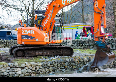 Le samedi 5 décembre 2015, Storm Desmond s'est écrasé dans le Royaume-Uni, la production de la UK's plus élevé jusqu'à 24 heures au total des précipitations 341.4mm. Elle a inondé le Lakeland village Shap, qui vient de commencer la réparation lorsqu'une autre période de forte pluie, le mercredi 9 décembre a causé l'Ullswater Beck pour éclater ses rives, causant la destruction d'autres encore. Cette photo prise le lendemain matin, le jeudi 10 décembre de creuseurs si vous essayez d'éliminer les débris d'inondation de la rivière. Banque D'Images