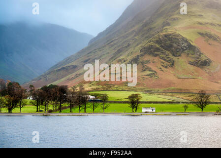 Un petit abri à bateau de bâtiments ou d'arbres sur la rive de Buttermere, Lake District, Cumbria UK à couvert l'hiver terne Banque D'Images