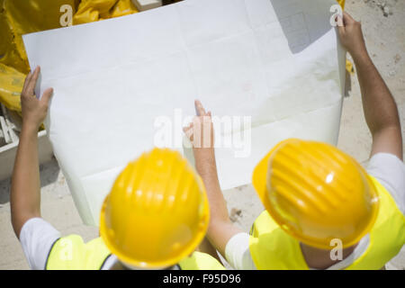 Gilet de sécurité en construction ingénieur avec blueprint at construction site Banque D'Images