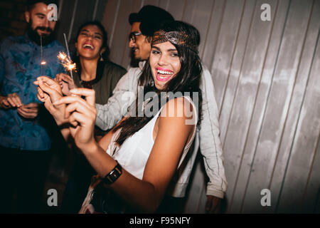 Tourné d'une jeune femme jouant avec des cierges dans la nuit. Best Friends 4 juillet à l'extérieur. Banque D'Images