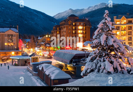 Le Village de Whistler s'allume avec des lumières au coucher du soleil sur une soirée d'hiver Banque D'Images