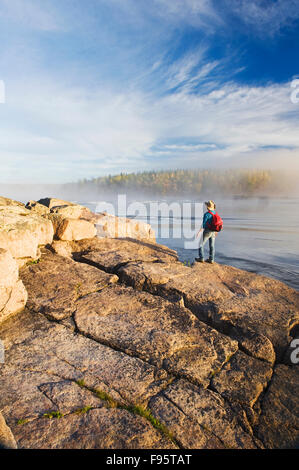 Randonneur sur Bouclier Canadien rock, Namau Lake, parc provincial de Whiteshell, Manitoba, Canada Banque D'Images