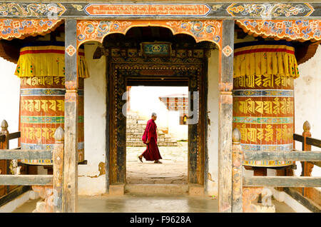 Un moine en passant par les portes avant du monastère bhoutanais Banque D'Images