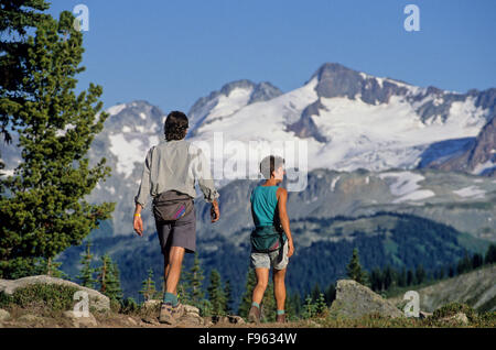 Deux randonneurs à pied le sentier de l'harmonie, le lac sur le mont Whistler, BC Canada Banque D'Images