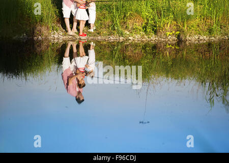 Heureux jeune père de la pêche sur le lac avec ses petites filles, reflétant dans l'eau Banque D'Images