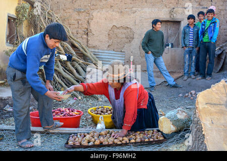 Préparation Faire cuire les pommes de terre et d'écolier à un internat pour le petit-déjeuner, sur un feu ouvert, de l'embarquement à Potosi, Bolivie Banque D'Images