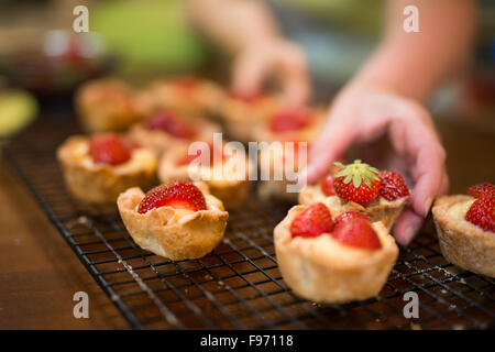 Grand-mère (58) et les petits-enfants (6 & 9) Crème pâtissière et Tartelettes aux fraises ensemble à partir de zéro Banque D'Images