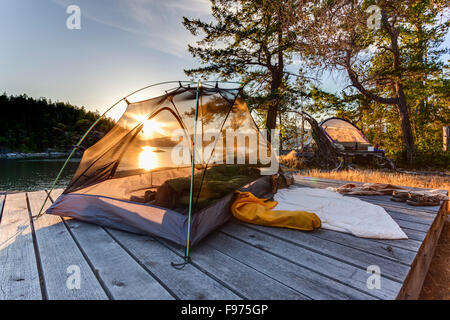 Le soleil se couche dans la tente de la kayakiste sur l'île ouest Curme. Le parc marin de Desolation Sound, en Colombie-Britannique, Canada. Banque D'Images