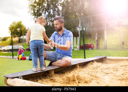 Smiling père et sa petite fille jouer sur l'aire de jeux. Banque D'Images