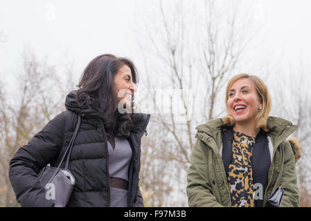 Deux belles jeunes femmes de parler, de sourire et de s'amuser à l'extérieur dans une froide journée d'automne. La lumière naturelle, peau naturelle, shot fr Banque D'Images