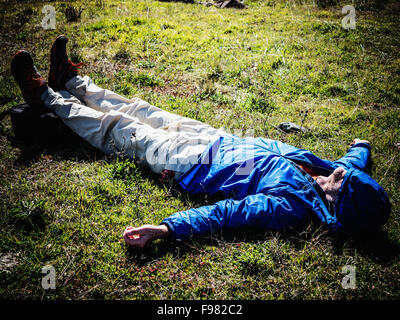 Un homme allongé sur le sol après une exhausing randonnée. Banque D'Images