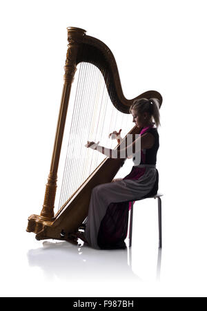 Silhouette de femme élégante robe en jouant de la harpe, isolé sur fond blanc Banque D'Images