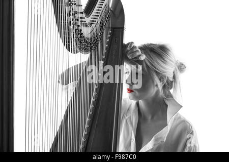 Noir et blanc photo de femme en chemise blanche avec harpe, isolé sur fond blanc Banque D'Images