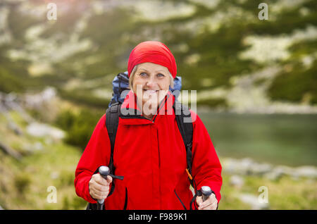 Tourisme Senior femme randonnée dans les belles montagnes Banque D'Images