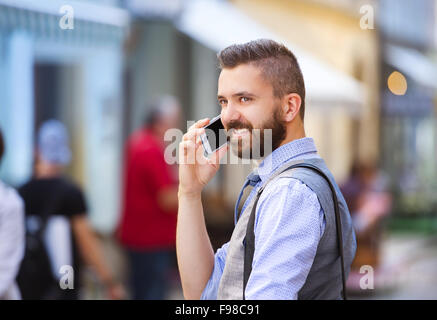 Handsome businessman moderne hipster avec balades en ville et barbe l'appel sur téléphone mobile Banque D'Images