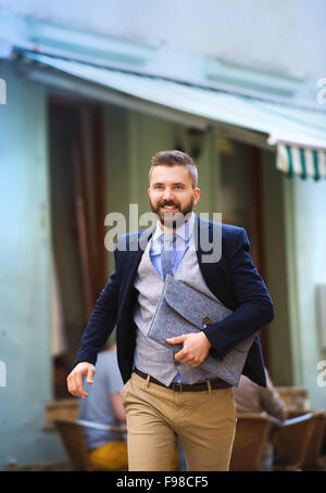 Beau hipster moderne businessman with briefcase se dépêchant de travailler Banque D'Images