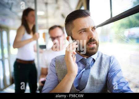 Beau hipster homme moderne appelant par téléphone mobile à tram Banque D'Images