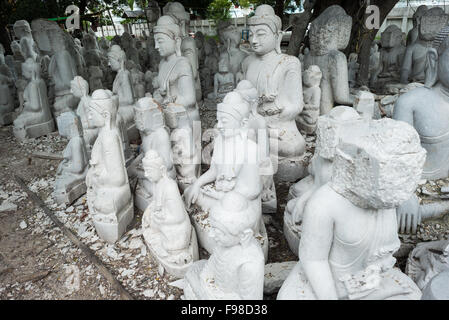 MANDALAY, Myanmar — les artisans locaux entreprennent le travail poussiéreux et épouvantable de sculpter des statues du Bouddha en marbre. Le bouddhisme étant la religion dominante au Myanmar, il y a une demande considérable pour les statues, avec des clients capables de choisir parmi une myriade de poses, tailles et styles. Les artisans sont regroupés dans une rue du quartier Chanmyathazi de Mandalay, près de la pagode Mahamuni. Banque D'Images